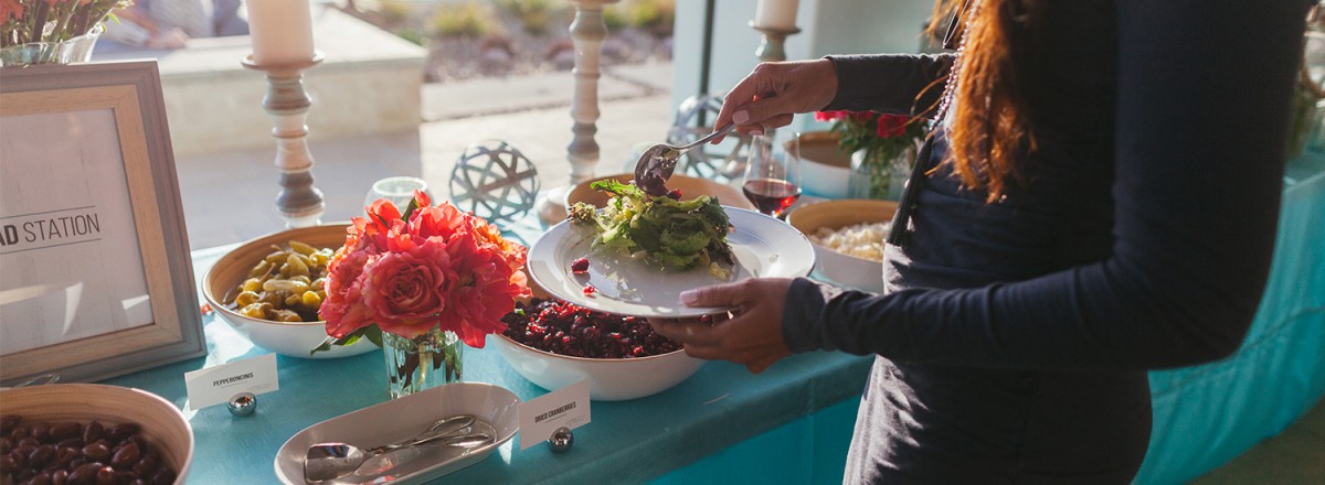 Woman serves salad at a catered event